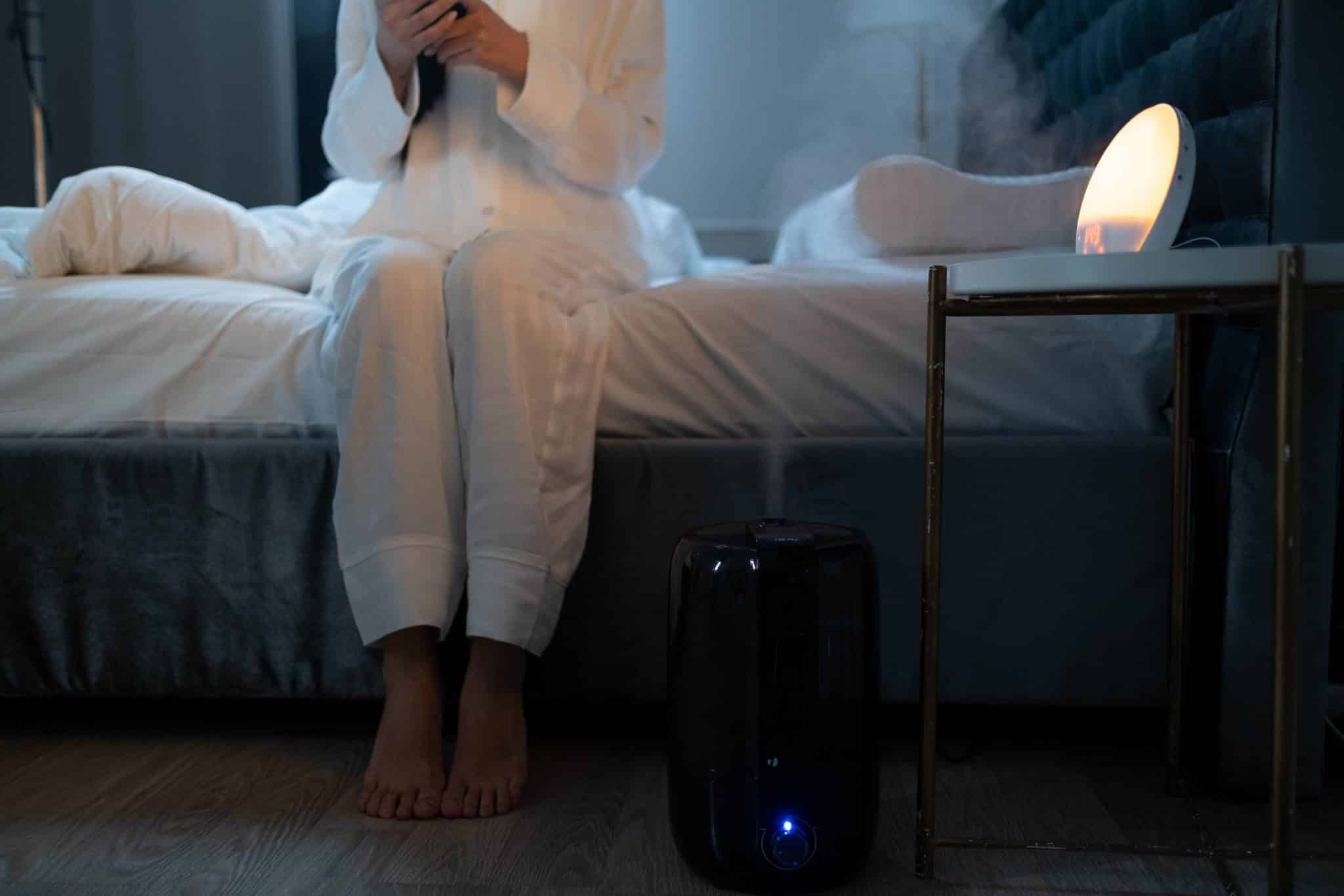 Woman with a humidifier next to her bed.