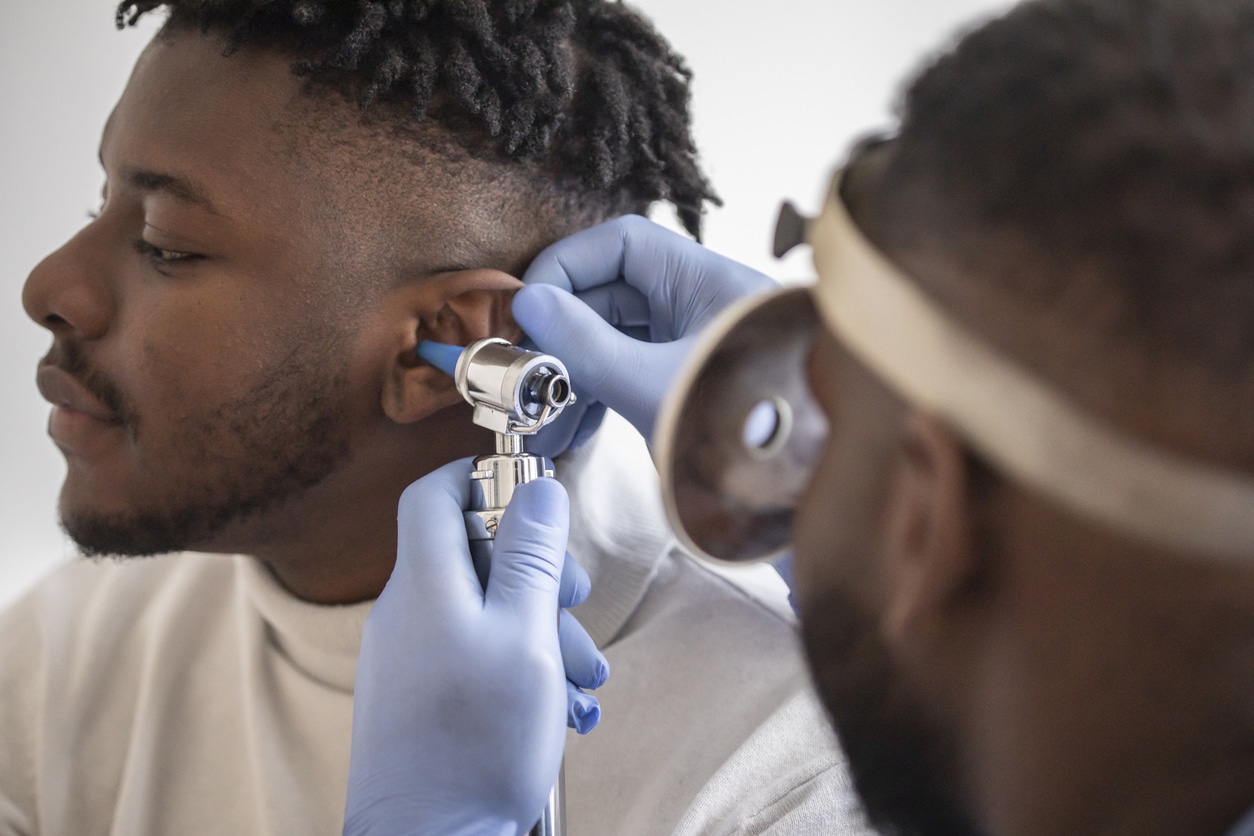 Doctor checking a man's eardrum