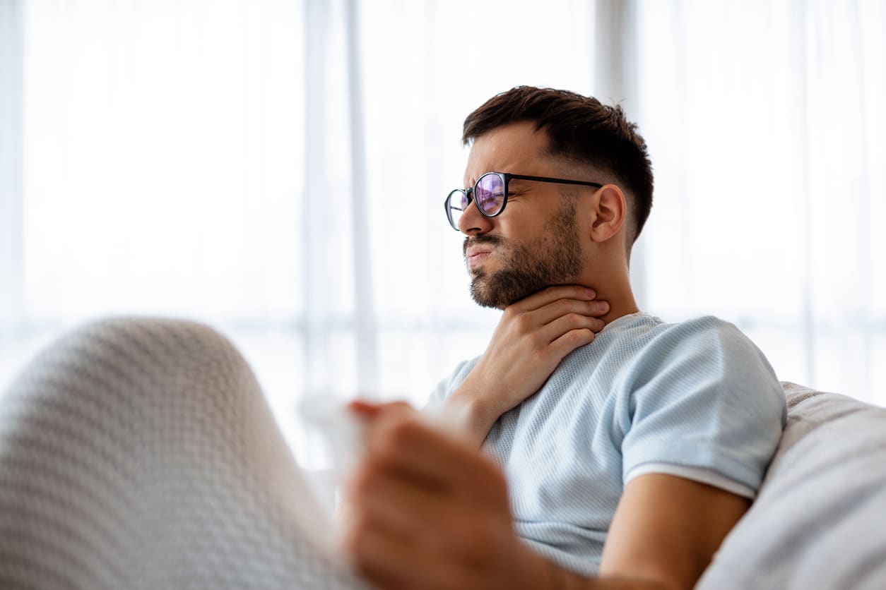 Man holding his sore throat