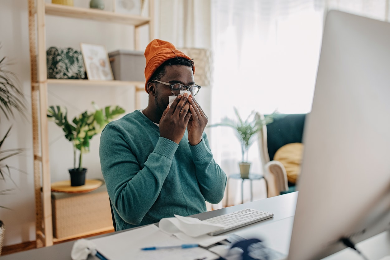 Man blowing his nose at home