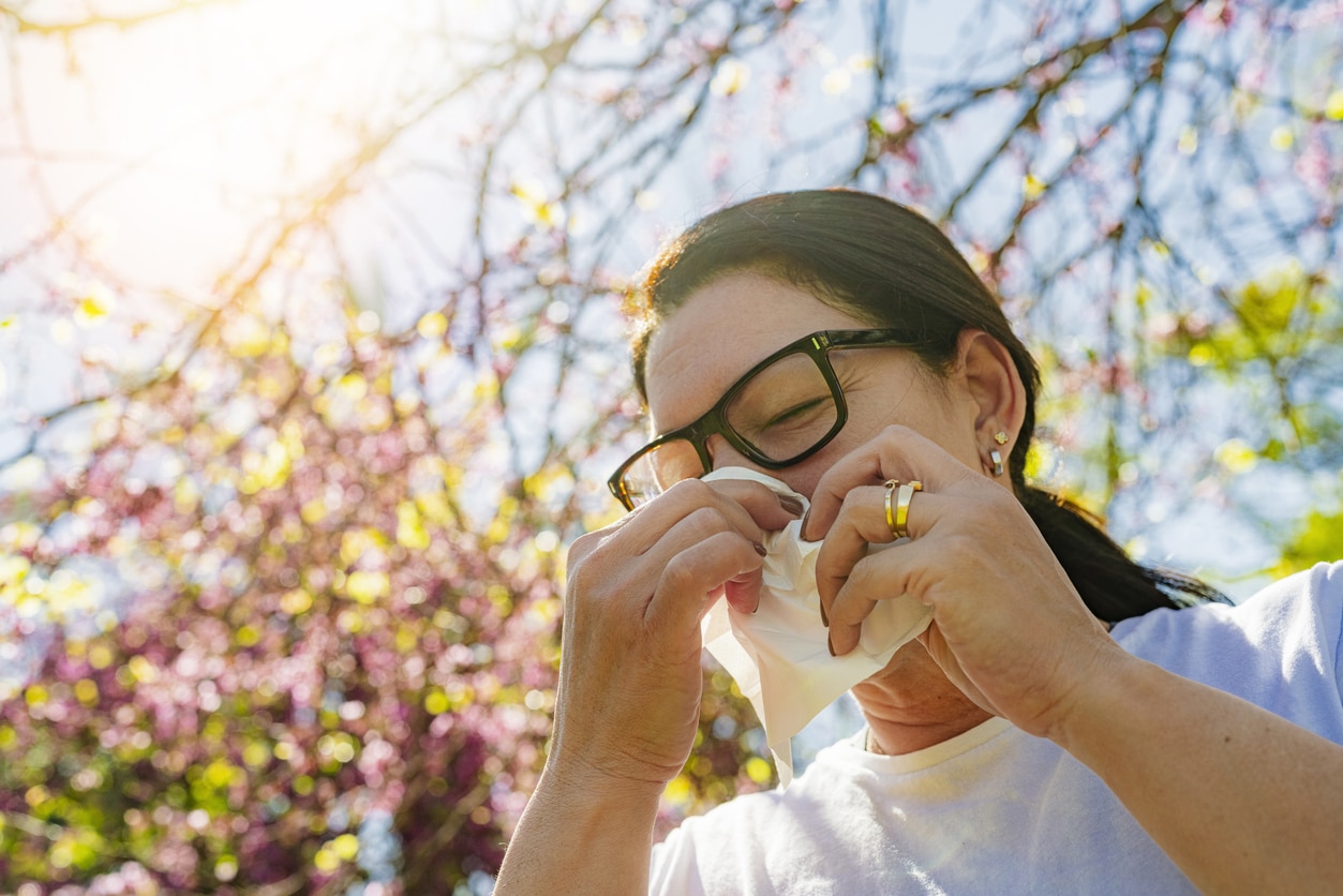 Woman sneezes in park