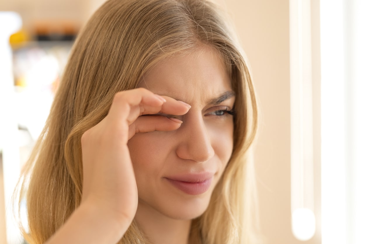Woman rubs eyes